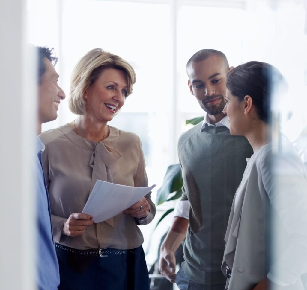 Un groupe de femmes et d'hommes discutent dans leur milieu de travail
