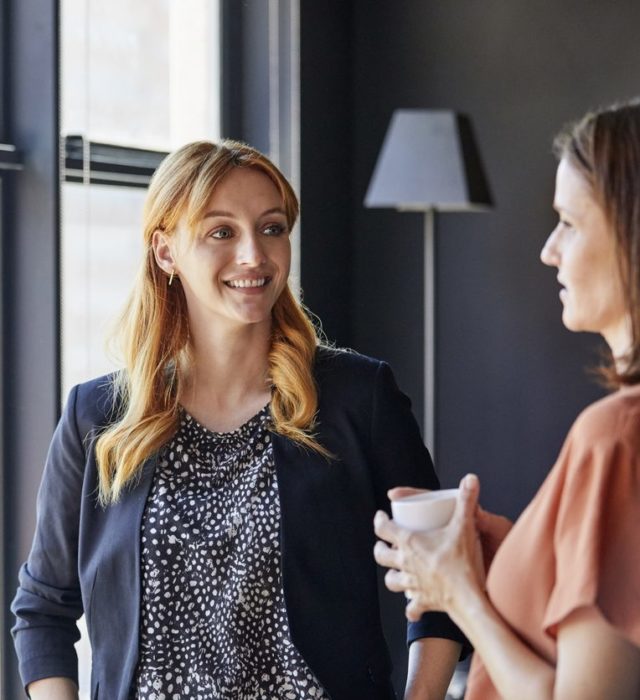 Femmes d'affaires discutant près d'une fenêtre